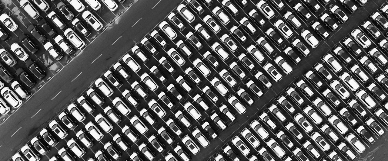 Rows of new cars seen from directly above in an inventory lot